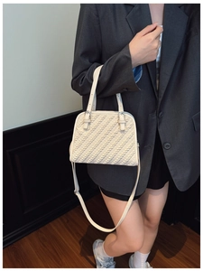 Detalle del bolso tote blanco roto con textura tejida diagonal y hebilla plateada