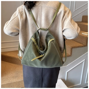 Detail of army green matte leather backpack with white stitching on carpet stairs