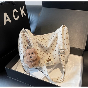 Détail du sac fourre-tout en velours côtelé blanc cassé avec motifs de cœur et breloque