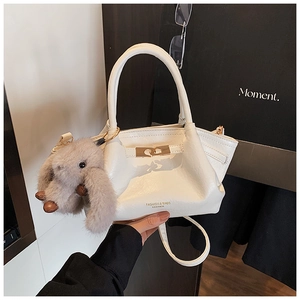 Détail du sac à main plissé blanc avec fermoir doré et charm de lapin en peluche