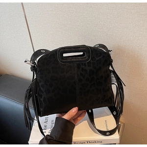 Détail du sac bandoulière noir imprimé léopard avec franges et bandoulière à œillets