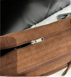 Detail of brown corduroy tote bag featuring a smooth-running silver metal zipper
