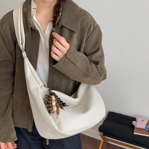 Close-up of cream white hobo bag with colorful ethnic beaded tassel decoration