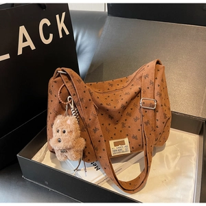 Détail du sac hobo en velours côtelé marron clair avec motifs cœurs et breloque