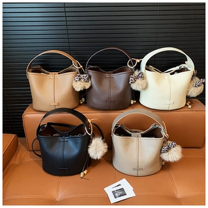Matrix display of leather bucket bags in five colors with leopard print pom-poms