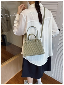 Bolso trenzado verde claro mostrado por modelo en un interior elegante de estilo moderno
