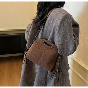 Vue latérale du sac seau léopard avec glands cloutés et poignée découpée élégante