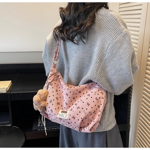Rosa Cord-Tasche mit schwarzem Schleifendesign und Plüsch-Anhänger an einem Schultergurt