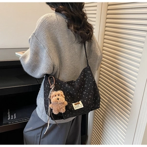 Détail du sac en toile avec motifs de cœur et charmant pendentif de chien en peluche