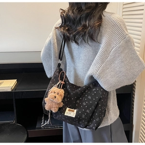 Détail du sac cabas en velours noir avec motifs papillons et breloque chien en peluche