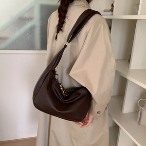 Detail of a dark brown leather hobo bag with vintage wooden beads and shoulder strap