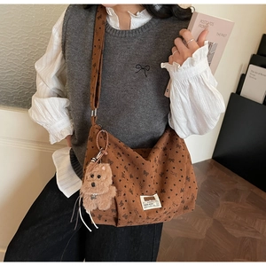 Détail du sac bandoulière en velours côtelé marron avec imprimés papillons et ours