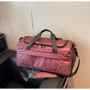 Close-up of wine red waterproof nylon gym bag featuring multi-pocket zipper detail