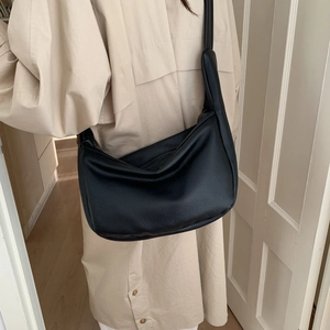 Detailed texture of black lychee grain leather on a vintage crescent underarm bag