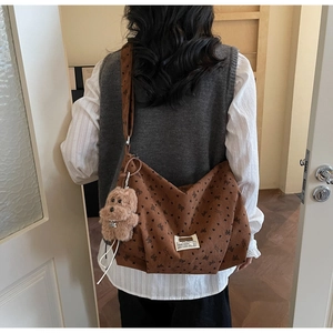 Sac cabas en velours côtelé marron avec motif papillon et breloque ours sur un mannequin