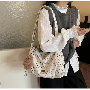 Détail du sac cabas en velours côtelé blanc avec motifs de cœurs et nœuds bruns