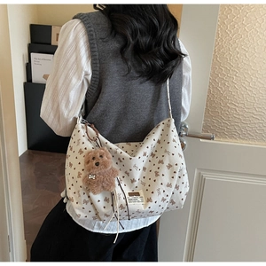 Détail du sac cabas en velours côtelé avec motifs nœuds et charm ours en peluche brun