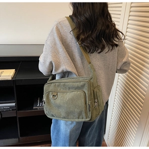 Detail of olive green corduroy tote bag with adjustable strap and metallic buckle