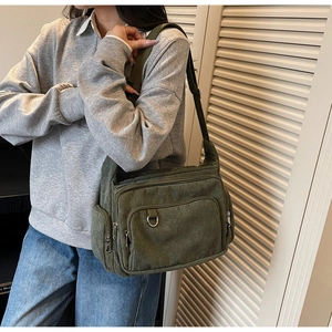 Detail of army green corduroy tote bag showing multiple pockets and adjustable strap