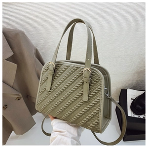 Detalle del bolso verde con acolchado ondulado y hebillas metálicas para un toque de moda