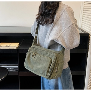 Detail view of large army green corduroy tote bag featuring multi-pocket utility design