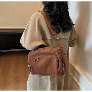 Detail showing brown corduroy tote bag texture and functional multi-pocket design