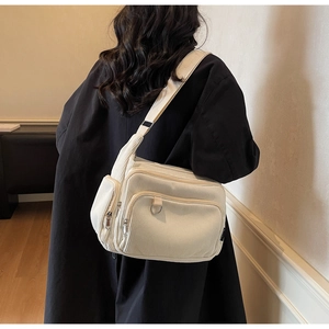 Detail of off-white corduroy tote bag featuring multi-pocket structure and adjustable strap