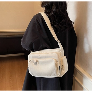 Detail of cream corduroy tote bag showing side pockets and soft ribbed texture
