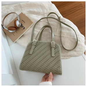 Detalle del bolso bandolera de cuero sintético verde con textura ondulada y dos asas