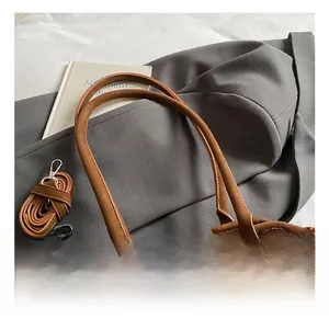 Détail du sac à main en cuir marron avec texture litchi et boucle en métal argenté