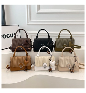 Muestra grupal de bolsos bandolera acolchados en V en seis colores con colgantes de corazón y cierres