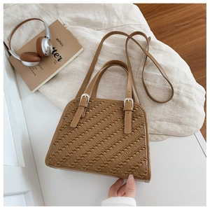 Detalle de bolso marrón acolchado con patrones de ondas y hebillas plateadas