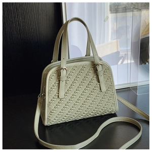 Detalle del bolso bandolera color crema con textura trenzada y correa ajustable