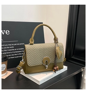 Detalle de bolso de cuero verde oscuro con solapa de cuadros y hebilla de aro plata