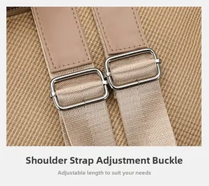 Detail of adjustable canvas shoulder strap with silver metal buckles and neat stitching