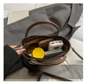 Detailed interior view of brown PU leather crossbody bag showing spacious storage capacity