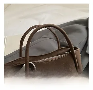 Detail of dark brown suede handbag with leopard print scarf and silver zipper closure