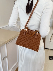 Bolso bandolera cuadrado marrón con textura trenzada y suéter de punto blanco suave