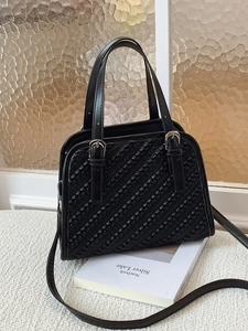 Bolso bandolera negro tejido minimalista con hebilla plateada ajustable y diseño moderno