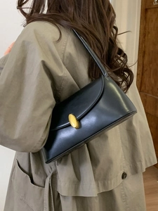 Minimalist black leather underarm shoulder bag with a vintage gold oval buckle