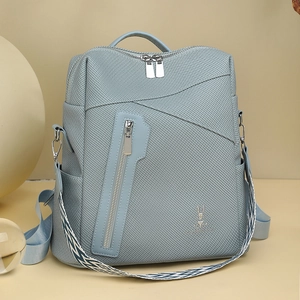 Detail of light blue versatile backpack with rabbit logo and geometric woven strap