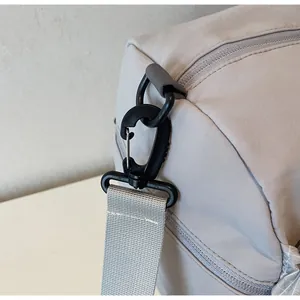 Detail of durable swivel hook and reinforced webbing strap on grey travel bag