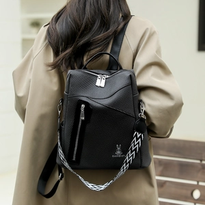 Detail of black textured fabric backpack with silver rabbit logo and geometric shoulder strap