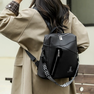 Detail of black backpack with woven texture and geometric patterned wide shoulder strap