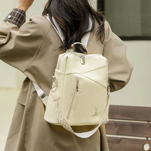 Detail of beige PU backpack showing textured finish, metallic zipper, and rabbit logo