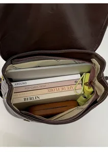 Vista interna dello zaino in pelle marrone con ampio spazio per laptop e libri
