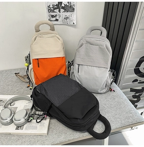 Détail de sacs à dos multifonctionnels en nylon avec grandes poignées et motif à carreaux