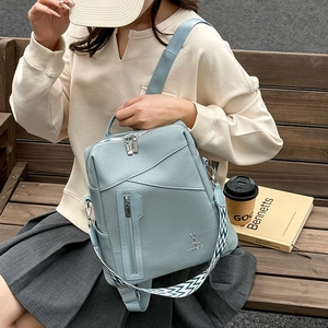 Detail of blue textured leather backpack with vertical zip and geometric strap