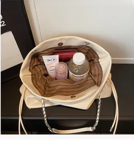 Top view of spacious cream tote bag interior with striped lining and silver chain strap