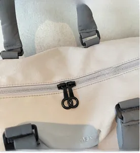 Detail of smooth black double zippers and logo on travel bag fabric surface
